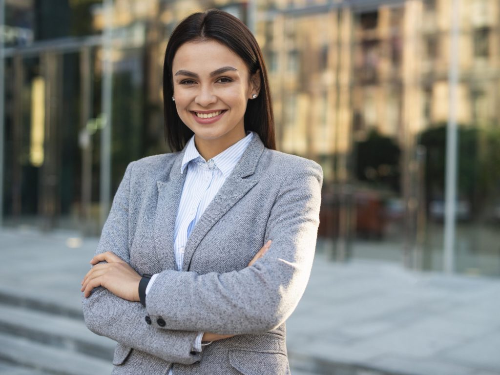 smiley-businesswoman-posing-outdoors-with-arms-crossed-copy-space